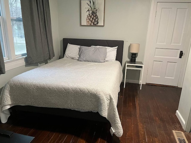 bedroom with dark wood-type flooring