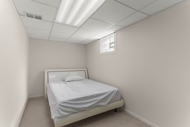 carpeted bedroom with a paneled ceiling