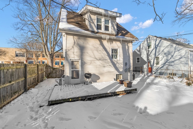 snow covered property with a fenced backyard