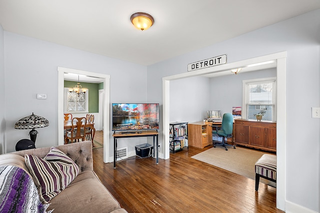 office space featuring baseboards, wood finished floors, and an inviting chandelier