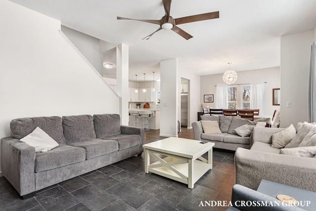 living room featuring ceiling fan with notable chandelier