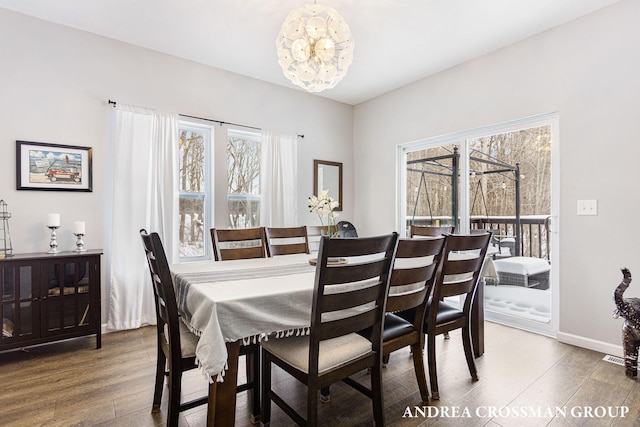 dining room with hardwood / wood-style floors and an inviting chandelier