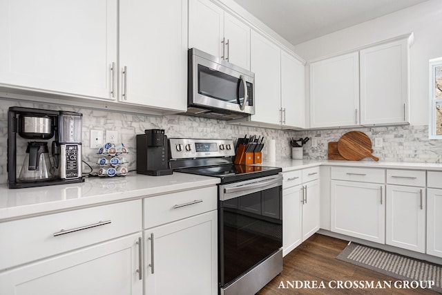 kitchen with dark hardwood / wood-style flooring, decorative backsplash, stainless steel appliances, and white cabinets