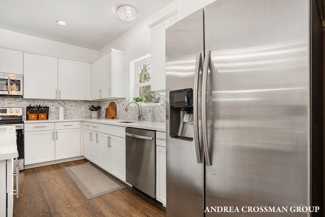 kitchen with sink, white cabinets, tasteful backsplash, and stainless steel appliances