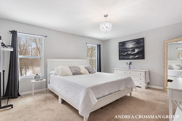 bedroom with multiple windows, an inviting chandelier, and light colored carpet