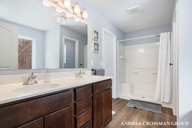 bathroom featuring hardwood / wood-style flooring, vanity, and walk in shower