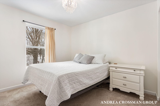 bedroom featuring a notable chandelier and dark colored carpet