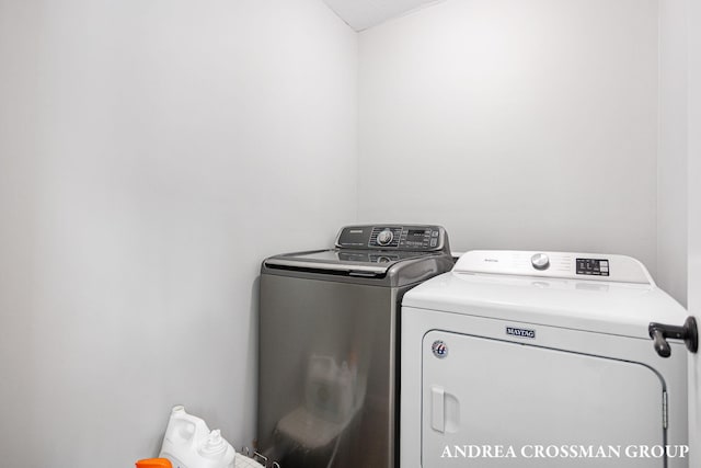 clothes washing area with washing machine and dryer