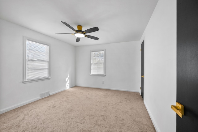 empty room with ceiling fan and light carpet