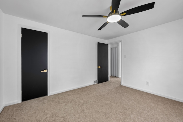 spare room featuring ceiling fan and light colored carpet