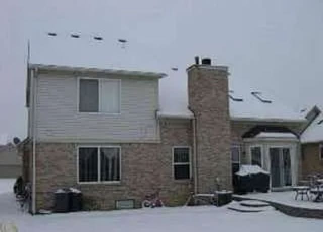 view of snow covered rear of property