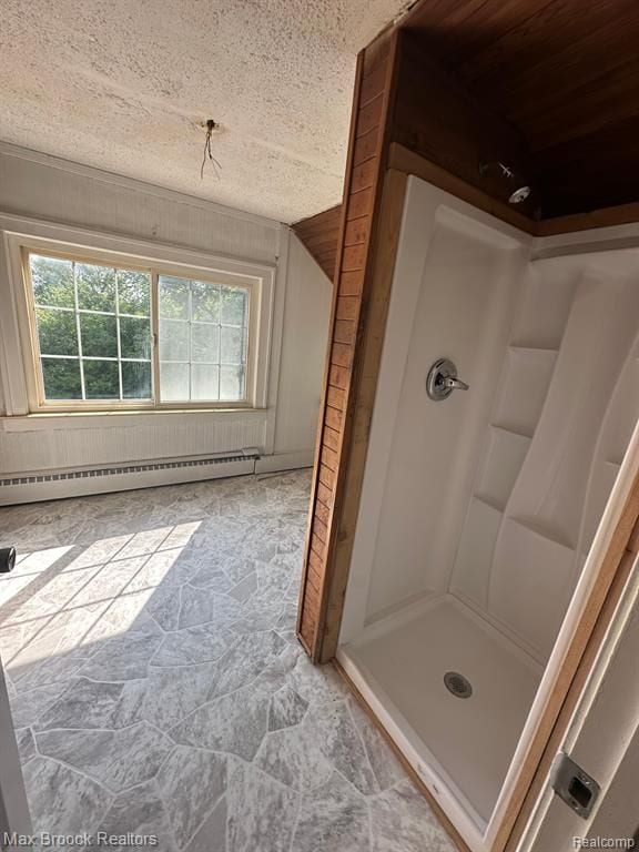 bathroom with a shower, baseboard heating, and a textured ceiling