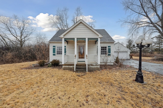 view of front of home with covered porch, roof with shingles, and a garage