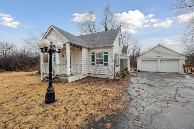 view of front of house with a garage, a shingled roof, and an outdoor structure