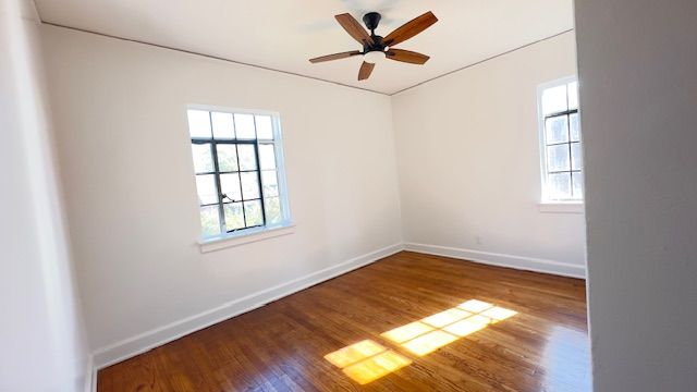 spare room with ceiling fan, baseboards, and wood finished floors