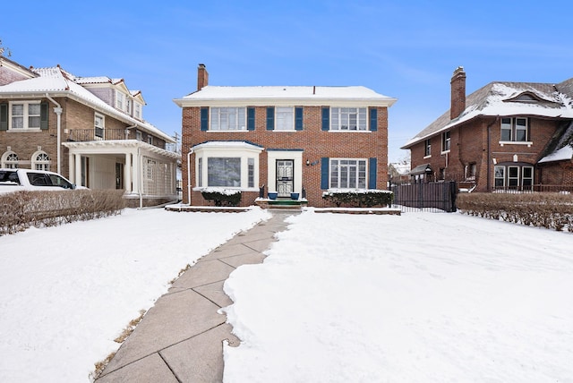 view of front of property featuring brick siding, fence, and a chimney