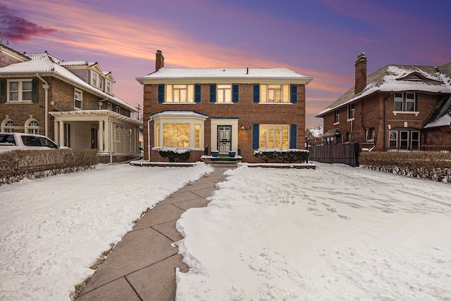 view of front of property featuring brick siding, a chimney, and fence