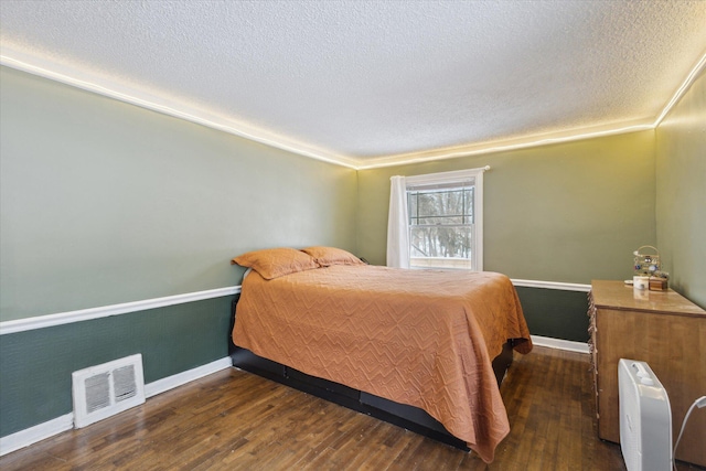 bedroom with dark wood-type flooring and a textured ceiling