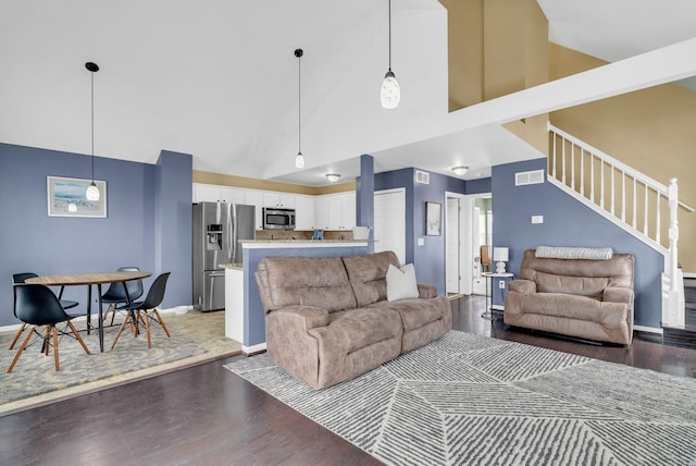 living room featuring high vaulted ceiling and dark hardwood / wood-style flooring