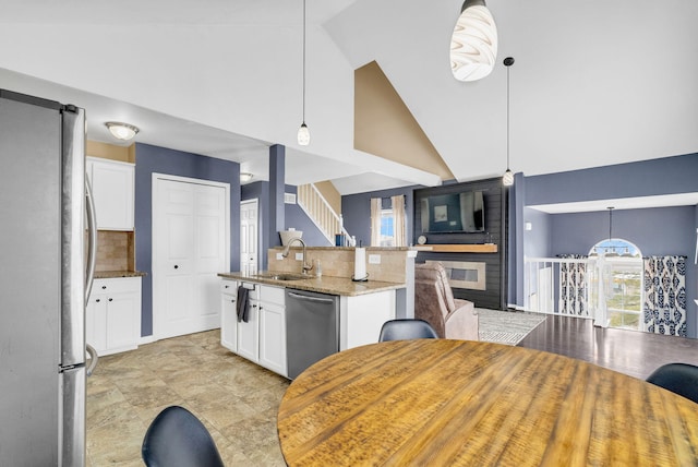 kitchen featuring appliances with stainless steel finishes, white cabinetry, and pendant lighting