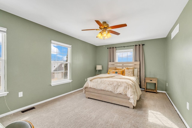 bedroom featuring multiple windows, ceiling fan, and carpet flooring