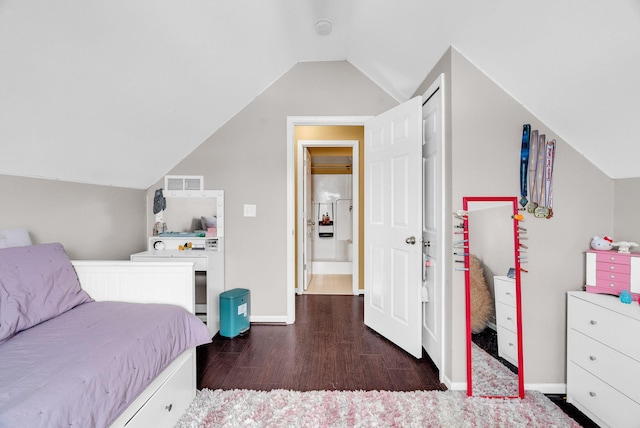 bedroom with vaulted ceiling, dark wood-type flooring, and washer / clothes dryer