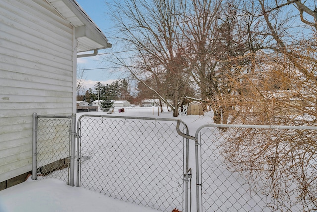 yard layered in snow featuring a gate and fence