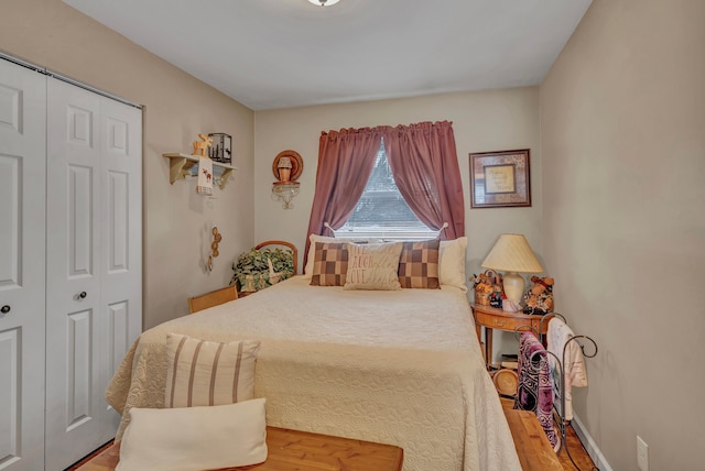 bedroom featuring a closet, baseboards, and wood finished floors