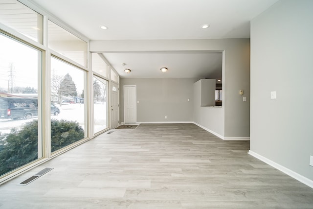 empty room featuring light hardwood / wood-style floors and floor to ceiling windows