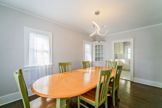 dining area featuring baseboards, a chandelier, dark wood-style flooring, and ornamental molding