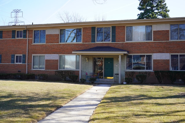 view of front facade featuring brick siding and a front yard