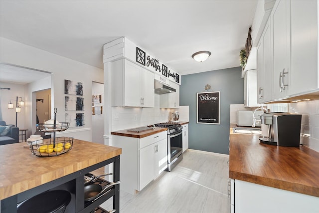 kitchen featuring white cabinets, stainless steel gas range oven, butcher block counters, and tasteful backsplash