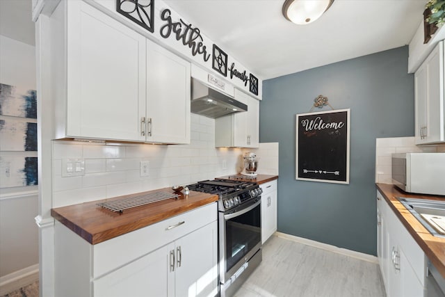 kitchen with light hardwood / wood-style flooring, tasteful backsplash, white cabinets, wood counters, and gas stove