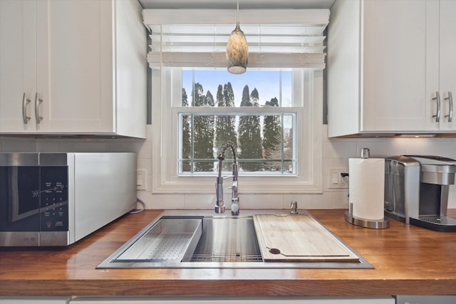 kitchen featuring white cabinets, pendant lighting, and sink