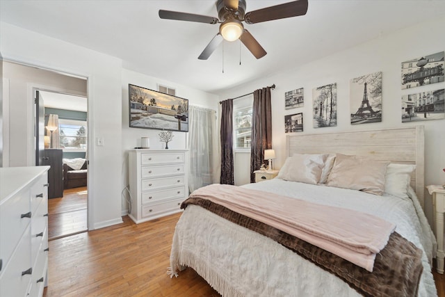 bedroom featuring light wood-type flooring, multiple windows, and ceiling fan