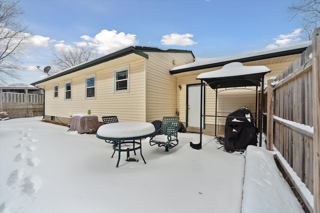 view of snow covered back of property