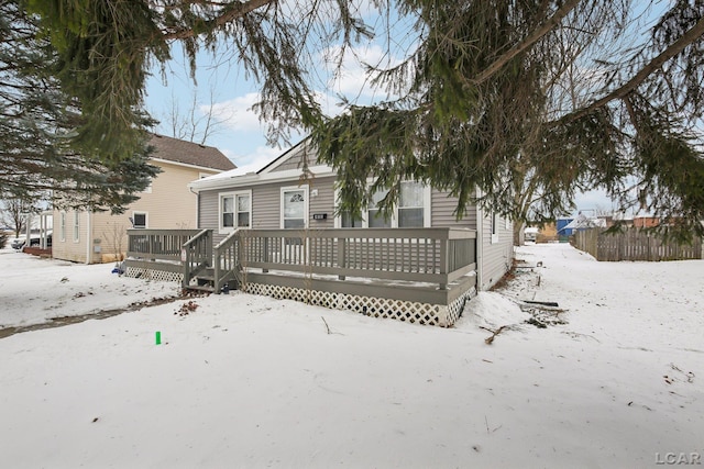 snow covered property with a wooden deck