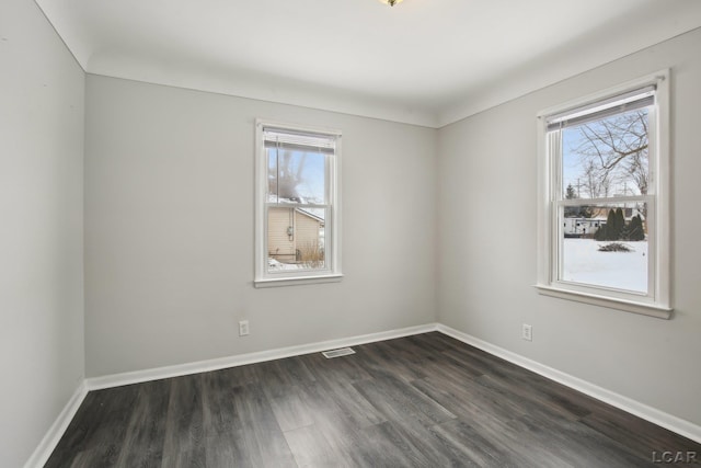 empty room with plenty of natural light and dark hardwood / wood-style flooring