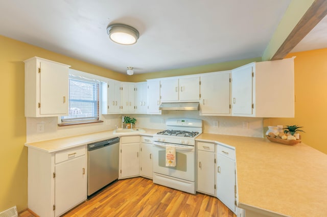 kitchen with stainless steel dishwasher, white range with gas cooktop, white cabinetry, and light hardwood / wood-style floors