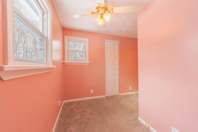 empty room featuring ceiling fan and light colored carpet