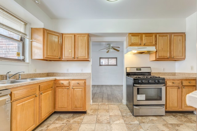 kitchen featuring stainless steel gas range oven, sink, dishwasher, and a healthy amount of sunlight