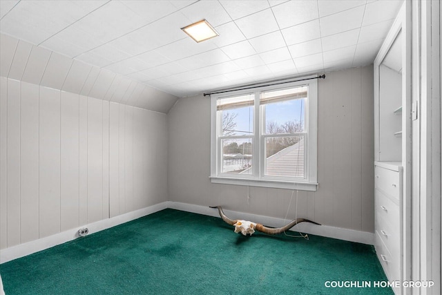 bonus room with lofted ceiling, wooden walls, and carpet flooring