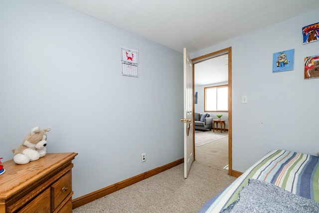 bedroom featuring light colored carpet and baseboards