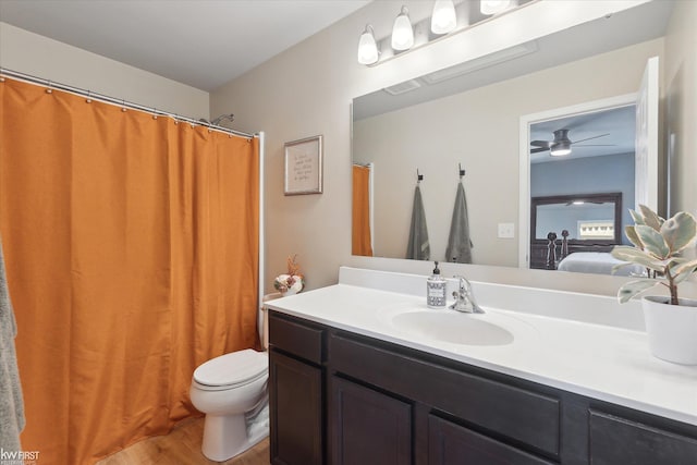 ensuite bathroom with vanity, wood finished floors, toilet, visible vents, and ensuite bathroom