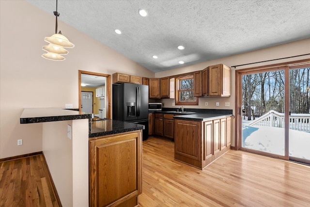 kitchen featuring dark countertops, decorative light fixtures, and a peninsula