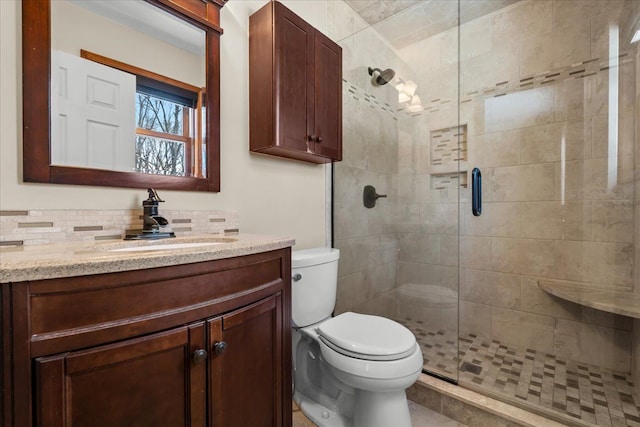 full bath featuring a stall shower, vanity, and toilet