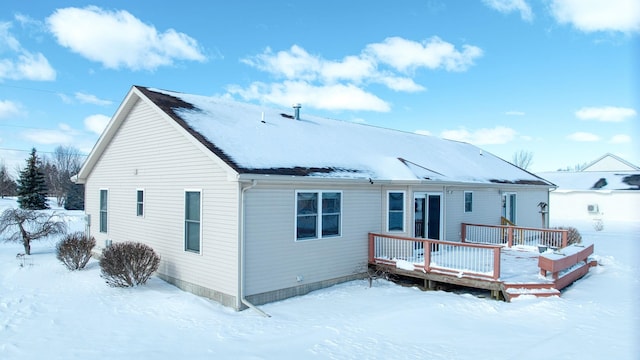 snow covered house featuring a deck