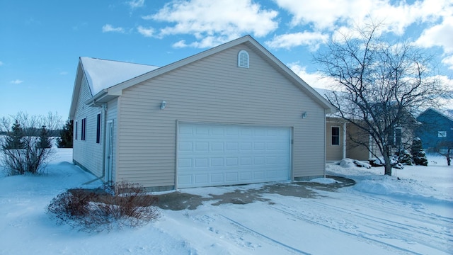 snow covered property featuring a garage