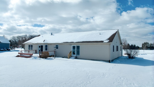 snow covered rear of property with entry steps