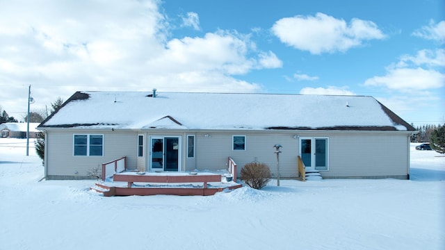 snow covered rear of property featuring entry steps